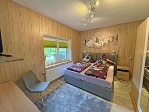 um quarto com uma cama, uma cadeira e uma janela em Neu Ferienwohnung Kriesten em Bad Brambach