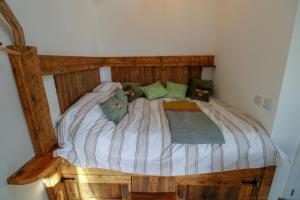 a wooden bed with pillows on it in a bedroom at The Beehive Warton in Warton