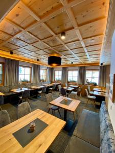 イシュグルにあるHotel Garni Alpenblickの木製の天井、テーブルと椅子のあるレストラン
