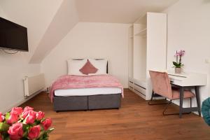 Un dormitorio con una cama y un escritorio y un escritorio. en Victoria Boardinghouse, en Düsseldorf