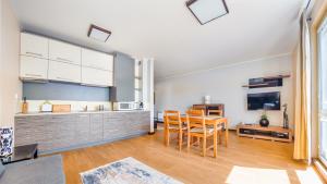 een keuken en eetkamer met een tafel en stoelen bij Apartamenty Sun & Snow Niska 10 in Krynica Morska