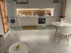 een keuken met witte apparatuur en een tafel en stoelen bij Athens Cosy Semi-Basement Apartment in Athene