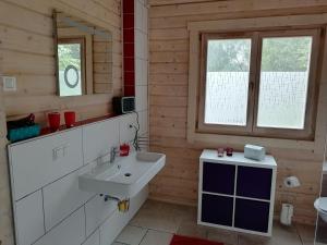 y baño con lavabo blanco y espejo. en Blockbohlenhaus-Steiner-Lodge, en Steinen