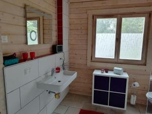 a bathroom with a white sink and a mirror at Blockbohlenhaus-Steiner-Lodge in Steinen +41 photos
