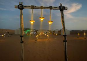 un grupo de luces en el desierto por la noche en Titanic Merzouga Camp en Merzouga