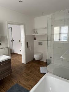 Baño blanco con aseo y lavamanos en Luxury Apartment near Munich Airport - Therme ED - Parking en Berglern