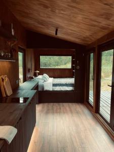 ein Zimmer mit einem Schlafzimmer mit Bett und Fenstern in der Unterkunft Bento Houses Domki w lesie, cisza pod Warszawą in Kąck