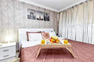 a bedroom with a bed with a tray of fruit on a table at Hotel Bed and Breakfast in Astana