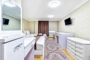 una sala de estar con una gran habitación blanca con sofá en Hotel Bed and Breakfast, en Astana