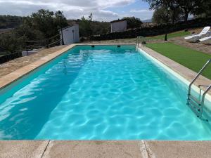 a swimming pool with blue water at Complejo Rural Los Molinos 