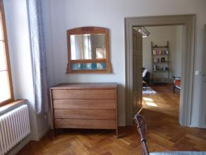 Cette chambre comprend une commode et un miroir mural. dans l'établissement Urgemütliches Apartment im Denkmal, à Halle-sur-Saale