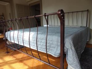 a metal bed with a blanket on top of it at Urgemütliches Apartment im Denkmal in Halle an der Saale