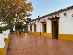 a yellow and white building with a patio at Complejo Rural Los Molinos 
