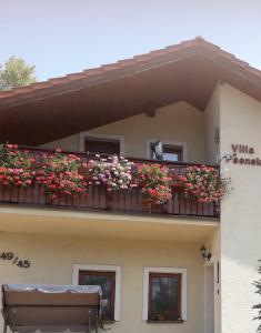 a building with a balcony with flowers on it at villa Pšenek benessere in Piešťany