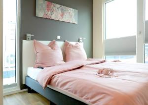 uma cama com lençóis cor-de-rosa e um par de sapatos em Floatinghouses BernsteinResort em Ribnitz-Damgarten