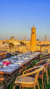 a group of tables with chairs and a lighthouse at Hotel Bankir Khiva in Khiva