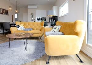 uma sala de estar com um sofá amarelo e uma mesa em Floatinghouses BernsteinResort em Ribnitz-Damgarten