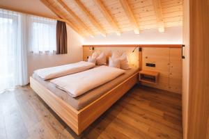 a bedroom with a large bed in a room at Elslerhof in Dobbiaco
