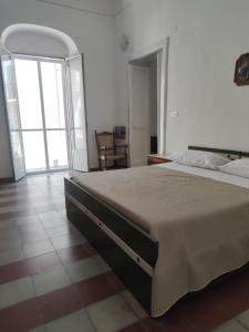 una camera da letto con un letto grande e una grande finestra di SOPRAMARE APPARTAMENTO a Rodi Garganico