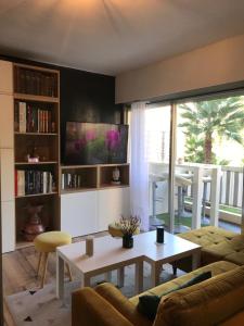 ein Wohnzimmer mit einem Sofa und einem Tisch in der Unterkunft La Petite Suite in Cannes
