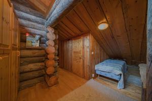 Lapland Cabin Levi في كيتيلا: غرفة مع سرير في كابينة خشب