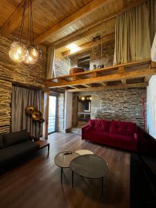 ein Wohnzimmer mit einem roten Sofa und einem Tisch in der Unterkunft CASAS DA FORTALEZA Casa da Torre in Outeiro de Rei