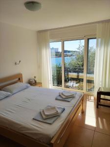 sypialnia z łóżkiem i dużym oknem w obiekcie Luxury Seaside Holm Oak Villa with Private Beach w Barze
