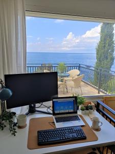 a desk with a laptop and a computer monitor and a balcony at Luxury Seaside Holm Oak Villa with Private Beach in Bar