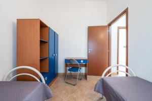 Habitación con 2 camas, escritorio y armario. en Is Lais appartamento 2, en Masainas