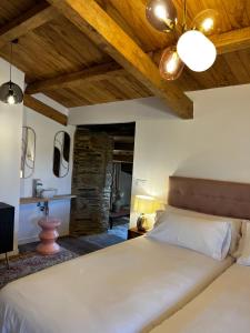 - une chambre avec un grand lit et un lavabo dans l'établissement CASAS DA FORTALEZA Casa da Torre, à Outeiro de Rei