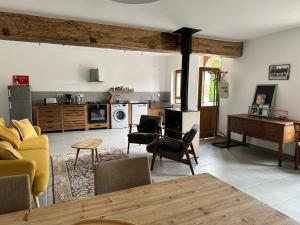 ein Wohnzimmer mit einem Sofa und einer Küche in der Unterkunft Longère en Sologne 2 in La Boullaye