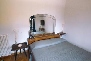 - une chambre avec un lit et un miroir mural dans l'établissement Casa Cerea, à Cerea