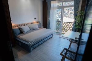 a bedroom with a bed and a large window at Tinker's Cabin Baguio in Baguio