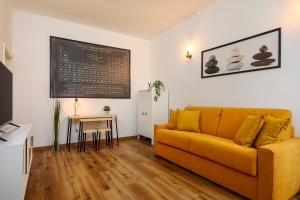 - un salon avec un canapé jaune et une table dans l'établissement Tito Livio 35 - Monolocale Cool, à Milan