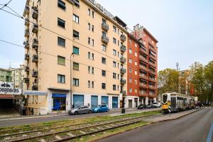 un train dans une rue de la ville avec des bâtiments et des voitures dans l'établissement Tito Livio 35 - Monolocale Cool, à Milan