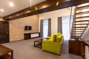 salon z żółtą kanapą i telewizorem w obiekcie Hotel-Restaurant Complex Vensky w mieście Browary