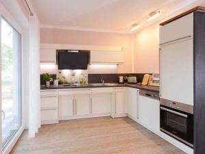 eine Küche mit weißen Schränken und einem großen Fenster in der Unterkunft Gezeiten App 2 Meeresrauschen in Boltenhagen