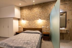 a bedroom with a bed and a brick wall at Hotel-Restaurant Complex Vensky in Brovary