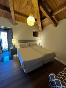 ein Schlafzimmer mit einem großen Bett und Holzdecken in der Unterkunft CASAS DA FORTALEZA Casa da Torre in Outeiro de Rei