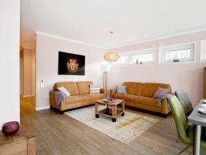 ein Wohnzimmer mit zwei Sofas und einem Tisch in der Unterkunft Gezeiten App 2 Meeresrauschen in Boltenhagen