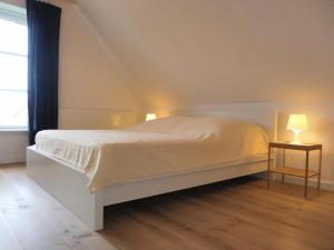 a white bed in a room with a window at Ferienhaus Fritid in Groß Schwansee +35 photos