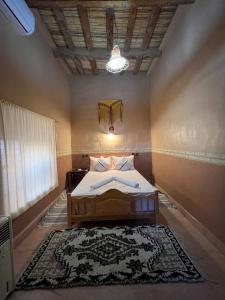 a bedroom with a bed and a rug on the floor at La perle de saghro in Nkob