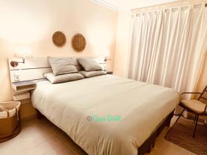 a bedroom with a large white bed with a window at Casa Brût - OLIVA NOVA in Oliva