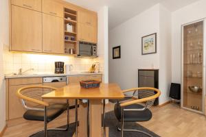 eine Küche mit einem Holztisch und Stühlen in der Unterkunft Villa Parkblick in Kühlungsborn + 2 Fotos