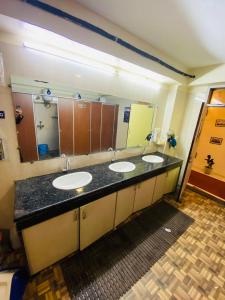 a bathroom with three sinks and a large mirror at Homestay Ac Dormitory in New Delhi