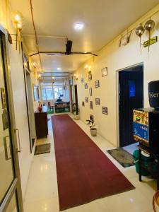 un corridoio con tappeto rosso in una camera di Homestay Ac Dormitory a Nuova Delhi
