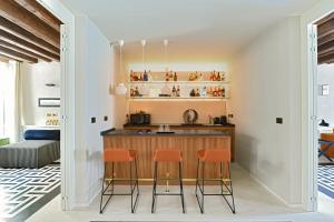 eine Küche mit einer Bar mit orangefarbenen Stühlen in der Unterkunft MorosiniBrandolinVenice in Venedig