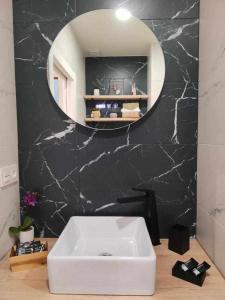 łazienka z białą umywalką i lustrem w obiekcie Apartamento Parras w Maladze