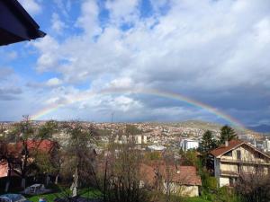 a rainbow in the sky over a city at Apartment Milkica in Sarajevo