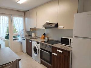 a kitchen with a refrigerator and a washer and dryer at La Marina Posada de LLanes VUT-3648-AS in Posada de Llanes